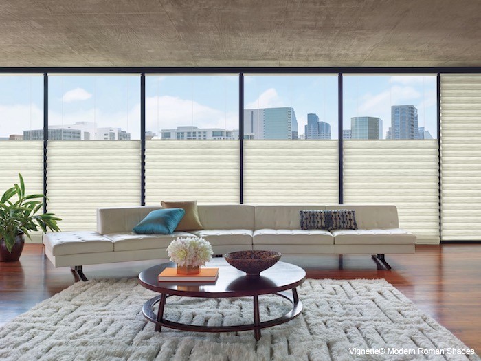 A living room with leather couch and plush carpet.